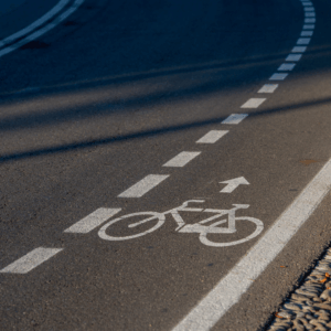 Markierter Radweg auf einer Straße mit Fahrradsymbol und Richtungspfeilen